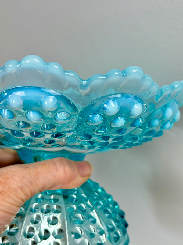 Close-up of aqua Fenton hobnail glass candle holder showing raised bubble texture and scalloped rim, held by hand