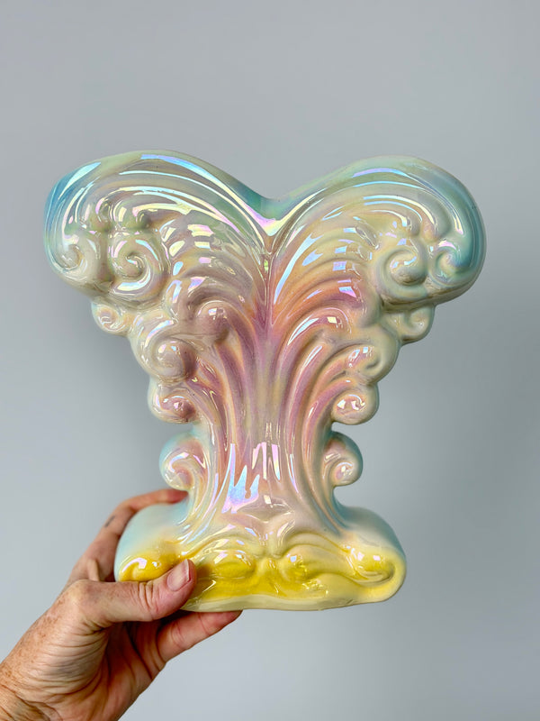 Hand holding Mingay lustreware vase against grey wall to show scale