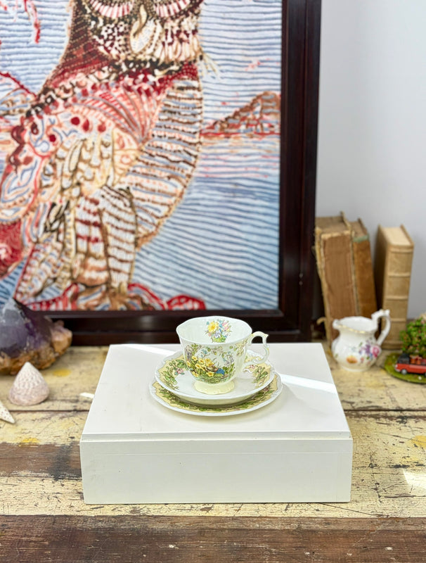 Royal Doulton Brambley Hedge Spring trio styled together, showing floral teacup, saucer and side plate on a white display plinth