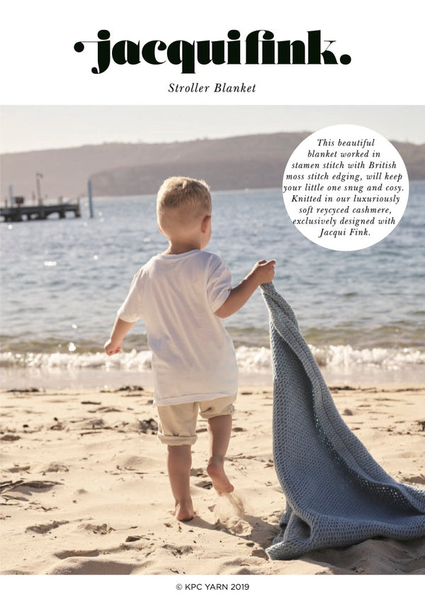 Front Cover of pattern showing Oli carrying the Stroller Blanket knitted in Grace Aran, our recycled cashmere yarn. Colour is Sky.